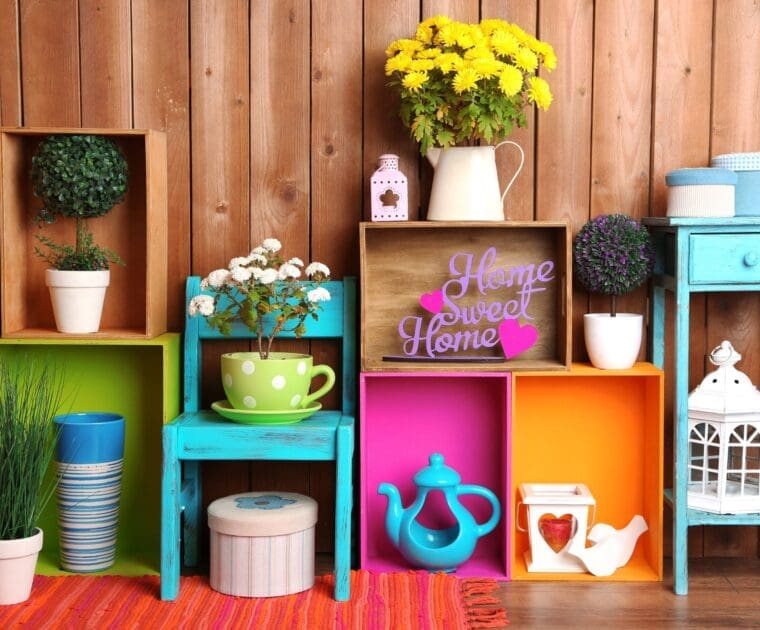 Wooden shelves painted in bright colors hold an assortment of vases and pots, creating a lively and decorative scene.