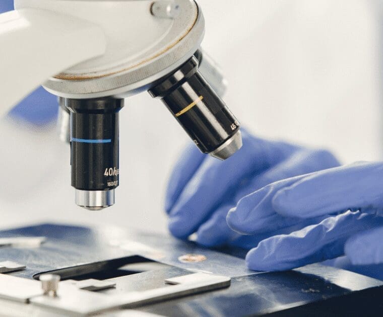 Scientist using a microscope to examine a sample